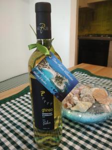una bottiglia di vino seduta sopra un tavolo di Casa Alessia a Villasimius