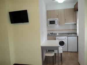 a small kitchen with a white counter and a dishwasher at Apartamentos Rurales Pernús in Colunga
