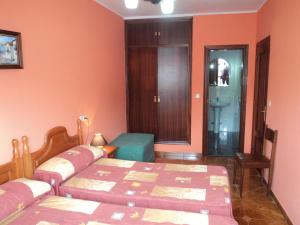 a bedroom with orange walls and a bed and a table at Apartamentos Rurales Pernús in Colunga