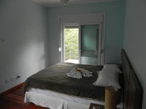 Un dormitorio con una cama grande con ventana. en V do Lago Negro - CASA, en Gramado