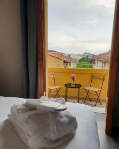 a white towel sitting on a bed in front of a window at G&G FIRENZE SUITES in Florence