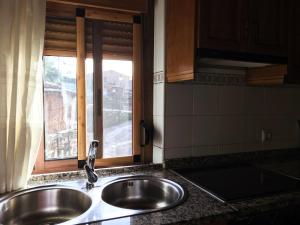 um lavatório numa cozinha com uma janela em Casa Barrero em Robledillo de Gata