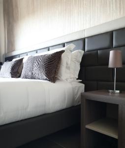 um quarto com uma cama com uma cabeceira e almofadas pretas em G&G FIRENZE SUITES em Florença