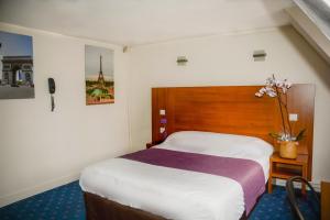 une chambre d'hôtel avec un lit et un vase de fleurs dans l'établissement Hotel Paris Bruxelles, à Paris