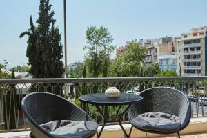 een tafel en 2 stoelen op een balkon bij Chic One Bd Apartment with Hilton View in Athene