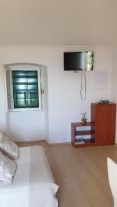 a white room with a bed and a window at Apartment Marina in Valun