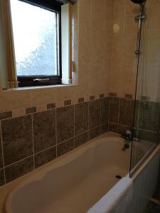 a bath tub in a bathroom with a window at Fox Heaven B&B in Carrickfergus