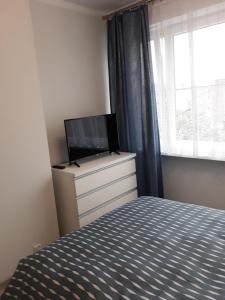 sypialnia z łóżkiem i telewizorem na komodzie w obiekcie Katrin House w Oświęcimiu