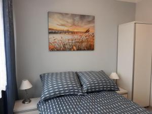 łóżko w sypialni z obrazem na ścianie w obiekcie Katrin House w Oświęcimiu