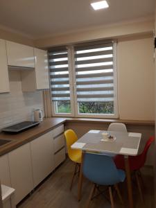 kuchnia ze stołem i krzesłami oraz 2 oknami w obiekcie Katrin House w Oświęcimiu