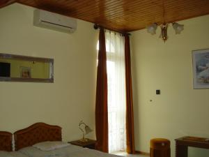 a bedroom with a bed and a large window at Royal Villa in Balatonfüred