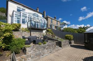 a house with a stone wall and a balcony at Trevona in Mousehole