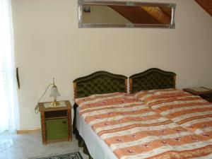 1 dormitorio con 1 cama y 1 mesa con lámpara en Royal Villa, en Balatonfüred