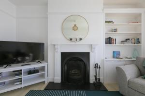 a living room with a fireplace and a tv at Trevona in Mousehole