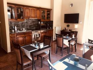 a dining room with two tables and a kitchen at Atrium Panzio in Esztergom