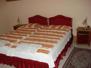 a large bed with a red headboard in a bedroom at Royal Villa in Balatonfüred