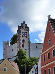um edifício alto com uma torre de relógio em cima em Lucky Home Ludwig Appartment em Füssen
