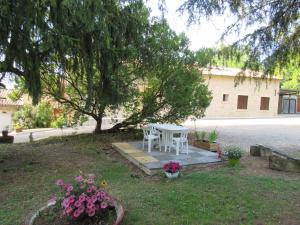 una mesa y sillas en un patio bajo un árbol en La Maison des Graves en Pujols Gironde