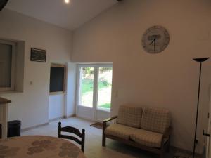 a living room with a clock on the wall at La Maison des Graves in Pujols Gironde