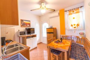 a kitchen with a table and a dining room at Sandra in Rab