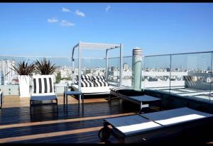 a balcony with two chairs and a gazebo on a roof at Topacio Tower apartamento de lujo in Buenos Aires