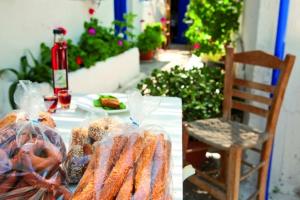 a table with food on it with a chair at Karkisia Hotel in Aegiali