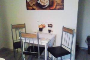einem Esstisch mit 2 Stühlen sowie einem weißen Tisch und Stühlen in der Unterkunft Kleines Apartement zwischen Ega und Messe Erfurt in Erfurt