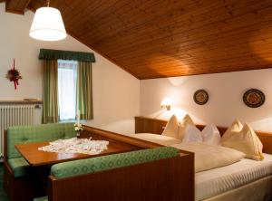 a hotel room with a bed and a table at B&B Residence Adria in Corvara in Badia