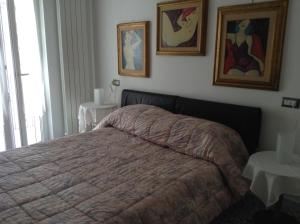 1 dormitorio con 1 cama y 2 cuadros en la pared en Casa Lorusso, en Bari