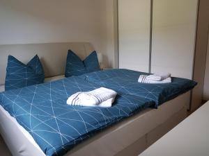 a blue bed with two white pillows and a mirror at Ferienwohnung Fischer in Kurort Gohrisch