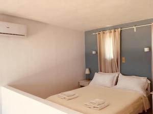 Theodosia Studios في كالاثاس: غرفة نوم صغيرة عليها سرير وفوط