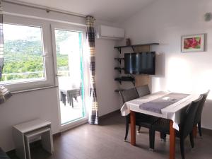 comedor con mesa, sillas y ventana en Villa Luce Apartment House, en Karlobag