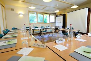 una sala de conferencias con una mesa grande y sillas en Campanile Cholet, en Cholet