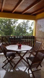 a table and chairs on a porch with a table and flowers at Les Gites du Bonheur in Deshaies