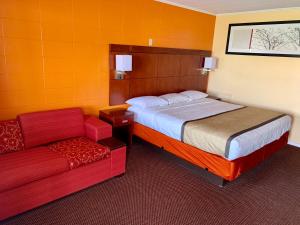 Habitación de hotel con cama y sofá en Budget Inn Mifflintown, en Mifflintown