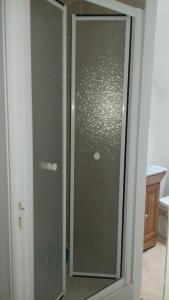 a glass shower door in a bathroom at Au Petit Bezion in Sarceaux