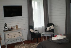 1 dormitorio con 1 cama, 2 sillas y TV en Le Chateau de la Barre, en Mosnes