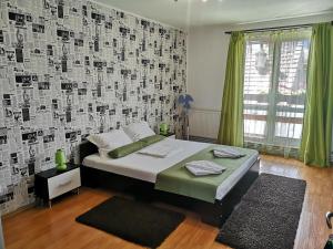 a bedroom with a bed and a wall with posters at Casa Mais in Braşov
