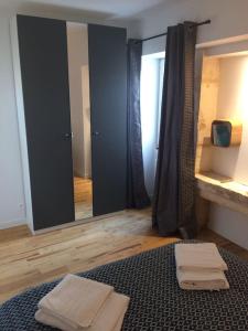 ein Badezimmer mit einem Spiegel und zwei Handtüchern auf einem Bett in der Unterkunft PETIT GITE EN BRACONNE in La Rochette