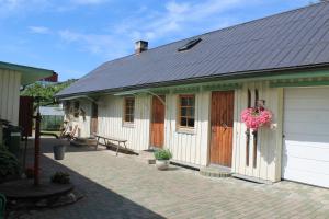 una pequeña casa con garaje y valla en Posti Holiday Home en Rakvere