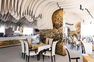 a restaurant with a ceiling made out of wood at White Tower Mamaia Apartament in Mamaia