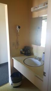 a bathroom with a sink, toilet and mirror at Safari Inn Motel in Winston
