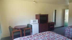 a hotel room with a bed and a television at Safari Inn Motel in Winston