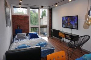 ein Wohnzimmer mit einem Sofa und einem TV an der Wand in der Unterkunft Apartament metro rondo Onz in Warschau