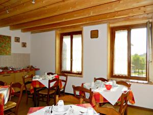 - une salle à manger avec des tables, des chaises et des fenêtres dans l'établissement Al Torcol Agriturismo, à Monzambano