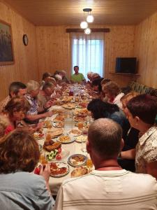 a group of people sitting around a long table eating food at Vodo's Guesthouse in Chvabiani