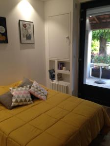 1 dormitorio con 1 cama con sábanas amarillas y ventana en CHAMBRE CENTRE VILLE Coté soleil en Forcalquier