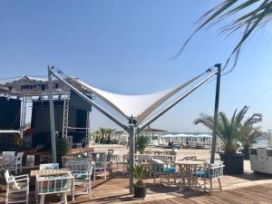 a group of tables and chairs on a deck at White Tower Mamaia Apartament in Mamaia