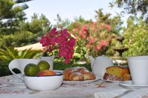 a table with a tea set with pastries and flowers at Villa Lidia in Paola