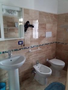 a bathroom with a sink and a toilet and a mirror at L'Artista B&B in Santa Lucia